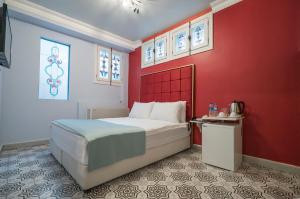- une chambre avec un lit et un mur rouge dans l'établissement Best Pasaport Pier Otel Kadıköy, à Istanbul
