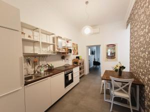 eine Küche mit weißen Schränken und einem Holztisch in der Unterkunft La tua casa a Piazza del Popolo in Rom