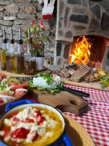 a table with a fireplace with food and a bowl of soup at Guest House BOZVILL in Bozovec