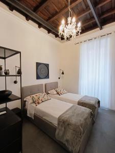1 Schlafzimmer mit 2 Betten und einem Kronleuchter in der Unterkunft La tua casa a Piazza del Popolo in Rom