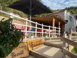 a building with an umbrella and a welcome sign at Guest House BOZVILL in Bozovec