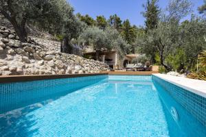 a blue swimming pool with trees and a house at Villa Son 3 in Mancor del Valle