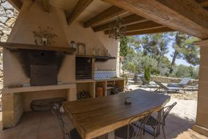 an outdoor kitchen with a table and a fireplace at Villa Son 3 in Mancor del Valle