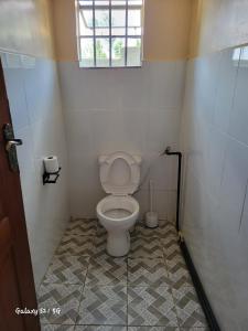 a bathroom with a toilet in a small room at Upperhill suites in Kisii