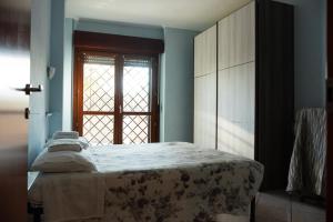 um quarto com uma cama grande e uma janela em Red House Tiburtina em Roma