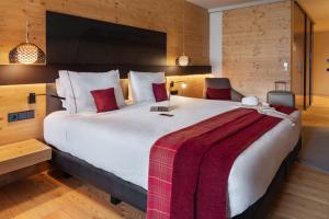 a bedroom with a large white bed with a red blanket at Park Piolets MountainHotel & Spa in Soldeu