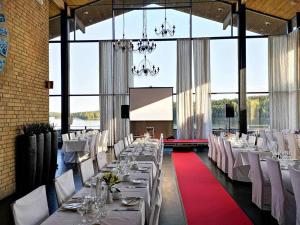 un comedor con mesas blancas y sillas blancas en Skåvsjöholm Hotell och Möten, en Åkersberga