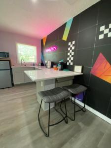 a kitchen with a counter and two stools in it at Totally 80s! in Sanford