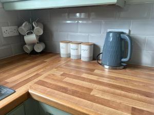 a counter top with three coffee cups and a blender at Morpeth town centre - Cottingburn House in Morpeth
