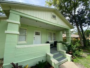 una casa verde con porche y puerta en Totally 80s!, en Sanford