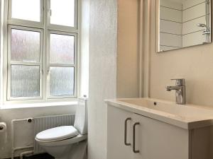 a bathroom with a toilet and a sink and a window at Three Bedroom Apartment In Kolding, Udsigten 4, in Kolding