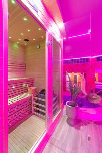 Szigetszentmárton的住宿－Mártoni Resort & Restaurant，粉红色的房间,里面装有植物的桑拿