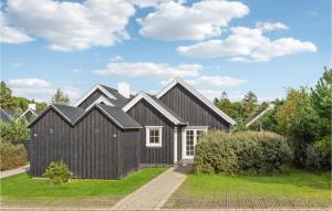 ein schwarzes Haus mit weißen Fenstern und einer Auffahrt in der Unterkunft Amazing Home In Gjern With Kitchen in Gjern