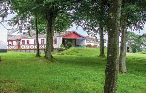 uma casa com um grupo de árvores em frente em Birknsgrd em Brædstrup