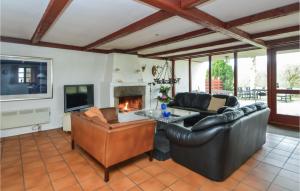 a living room with leather furniture and a fireplace at Birknsgrd in Brædstrup