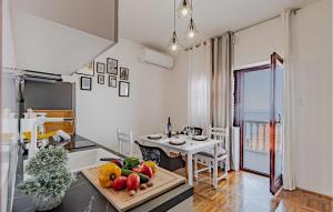 a kitchen and dining room with a table with fruit on it at 2 Bedroom Nice Apartment In Prigradica in Prigradica