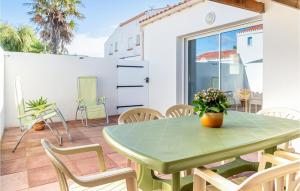 ラ・フォット・シュル・メールにあるAmazing Home In La Faute Sur Mer With 3 Bedrooms And Wifiの緑のテーブルと椅子が備わるパティオ