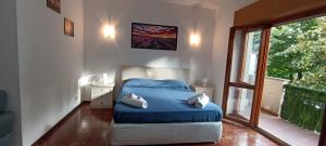 een slaapkamer met een blauw bed en een raam bij La Dimora del Lago in Genzano di Roma