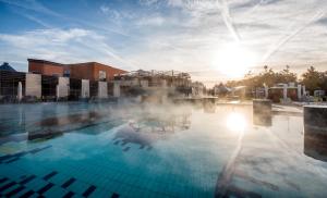 una piscina climatizada con vapor saliendo de ella en Berill Suites, en Sárvár