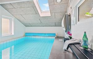 BrovstにあるNice Home In Brovst With 4 Bedrooms, Wifi And Indoor Swimming Poolの青いタイルフロアの大型スイミングプール