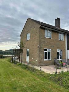 ein Backsteinhaus mit einem grasbewachsenen Hof davor in der Unterkunft Herne view maisonette beautiful countryside views in Ilminster