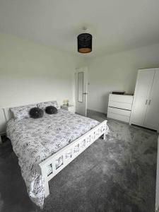 ein weißes Bett in einem Schlafzimmer mit einer weißen Wand in der Unterkunft Herne view maisonette beautiful countryside views in Ilminster