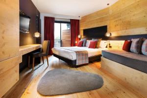 ソルデュにあるPark Piolets MountainHotel & Spaのベッドとデスクが備わるホテルルームです。
