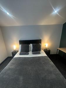 a bedroom with a large bed with two lamps at OYO The Avenue in Scunthorpe