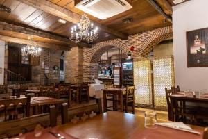 a restaurant with tables and chairs and a brick wall at Hotel Aroi Bierzo Plaza in Ponferrada