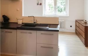 a kitchen with white cabinets and a sink at Lovely Apartment In Gdynia With Wi-fi in Gdynia