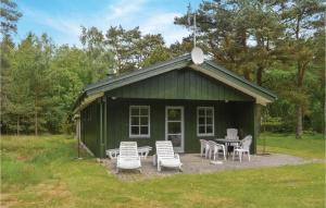 HelberskovにあるAmazing Home In Hadsund With 3 Bedrooms And Wifiの緑豊かなキャビン(テーブルと椅子付)
