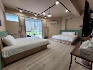 1 dormitorio con 2 camas y TV. en 敘時光行旅 Telling Story House, en Sanxing