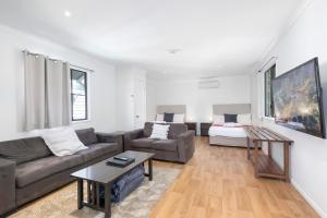 a living room with a couch and a table at Mossman Resort Holiday Villas in Mossman +17 photos