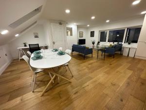 een eetkamer en een woonkamer met een witte tafel en stoelen bij Super 1 bedroom in a stunning apartment with shared kitchen and living room - 2C The Charteris in Londen