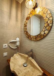 a bathroom with a stone sink and a mirror at Chakra House Fuerteventura in Corralejo