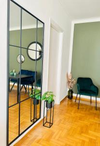 a mirror in a room with a table and a chair at Chez Ethan, 5 min à pied de l'Acropole in Athens