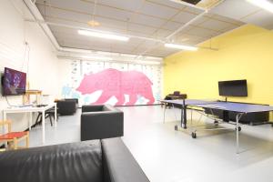 a room with ping pong tables and a pink pig on the wall at Forenom Hostel Espoo Kilo in Espoo