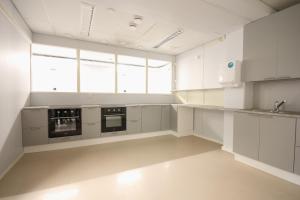 エスポーにあるForenom Hostel Espoo Kiloの白いキャビネットと家電製品を備えた広いキッチン +30枚の写真