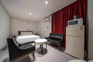 a small room with a bed and a table and chair at Pacific7 Hotel in Pyeongtaek