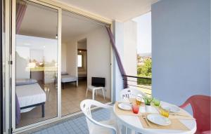 Zimmer mit einem Tisch und Stühlen sowie einem Balkon in der Unterkunft Amazing Apartment In Isca Marina With Wifi And 1 Bedrooms in Badolato