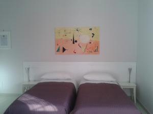 two beds in a room with a painting on the wall at Residenza Guglielmi in Campobasso