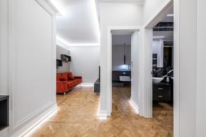 sala de estar con paredes blancas y suelo de madera. en Beccaria - Florence luxury Apartment, en Florencia