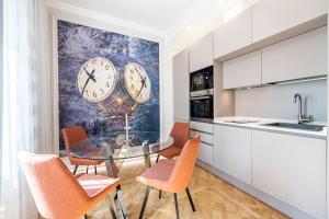 cocina con mesa de cristal y relojes en la pared en Beccaria - Florence luxury Apartment, en Florencia