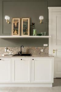 a kitchen with white cabinets and a sink at Avanti Palazzo in Krakow