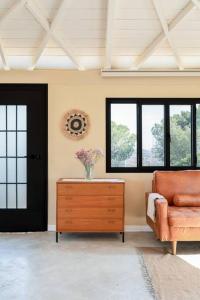 uma sala de estar com uma cadeira, uma cómoda e uma porta em בית בהר- בקתה יפיפיה בקצה הגלבוע em Sede Terumot