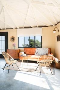 sala de estar con 2 sillas y sofá en בית בהר- בקתה יפיפיה בקצה הגלבוע en Sede Terumot