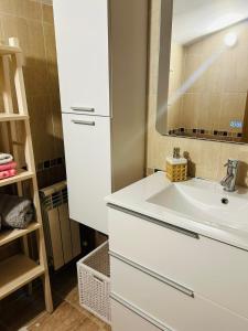 W białej łazience znajduje się umywalka i lustro. w obiekcie Ático a 8 minutos de Toledo y 15 del Puy Du Fou w mieście Bargas