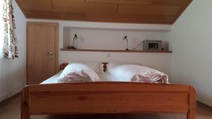 1 dormitorio con 1 cama con almohadas blancas en Haus Vallaster, en Sankt Gallenkirch