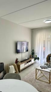 ein Wohnzimmer mit einem Flachbild-TV an der Wand in der Unterkunft APOLLO LUXURY APARTMENT in Sandton
