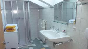 y baño blanco con lavabo y ducha. en Haus Vallaster, en Sankt Gallenkirch